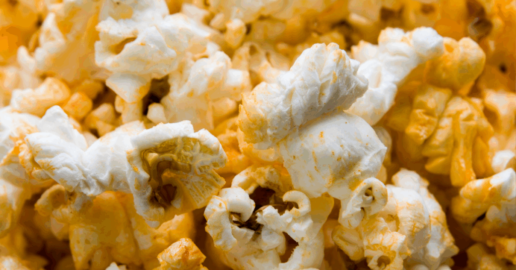 Bowl of popcorn coated in golden nutritional yeast and spices.